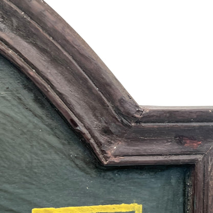 Corner of a framed picture with a dark brown frame and green interior.