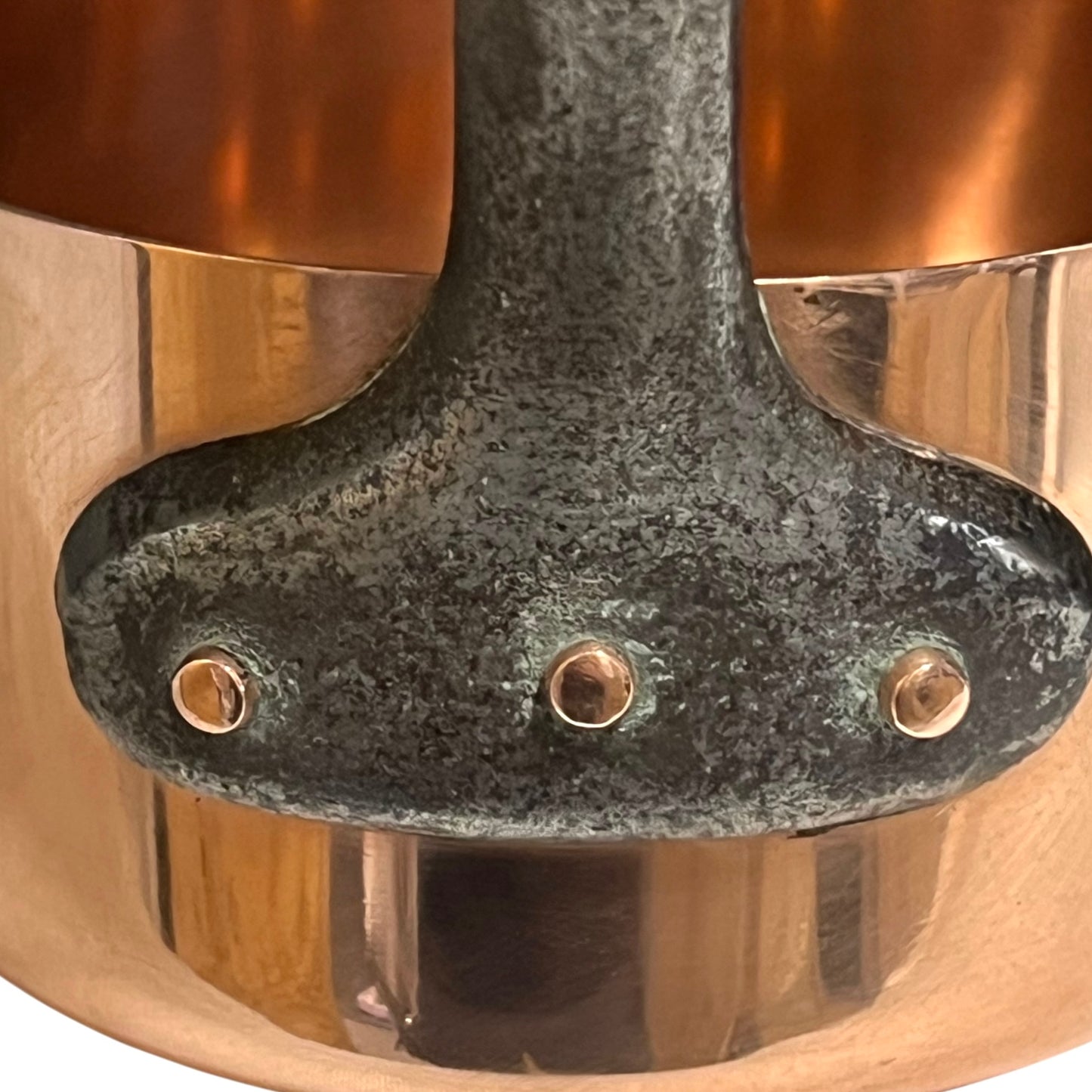 Close-up of a copper pot with a metal handle on a white background