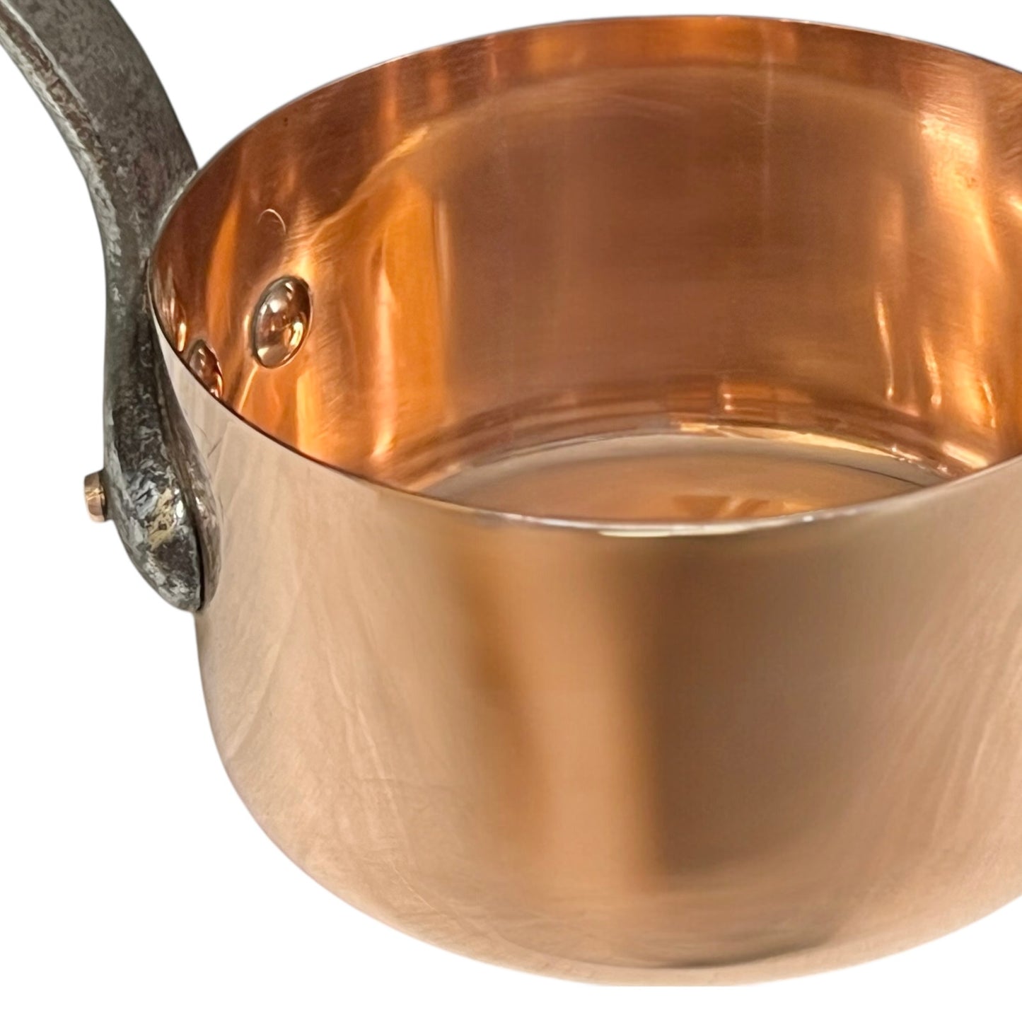Close-up of a copper pot with a metal handle on a white background