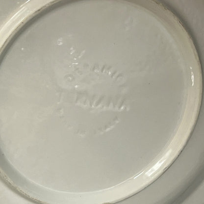 Back of La Raclette plate with a makers stamp on a white background 