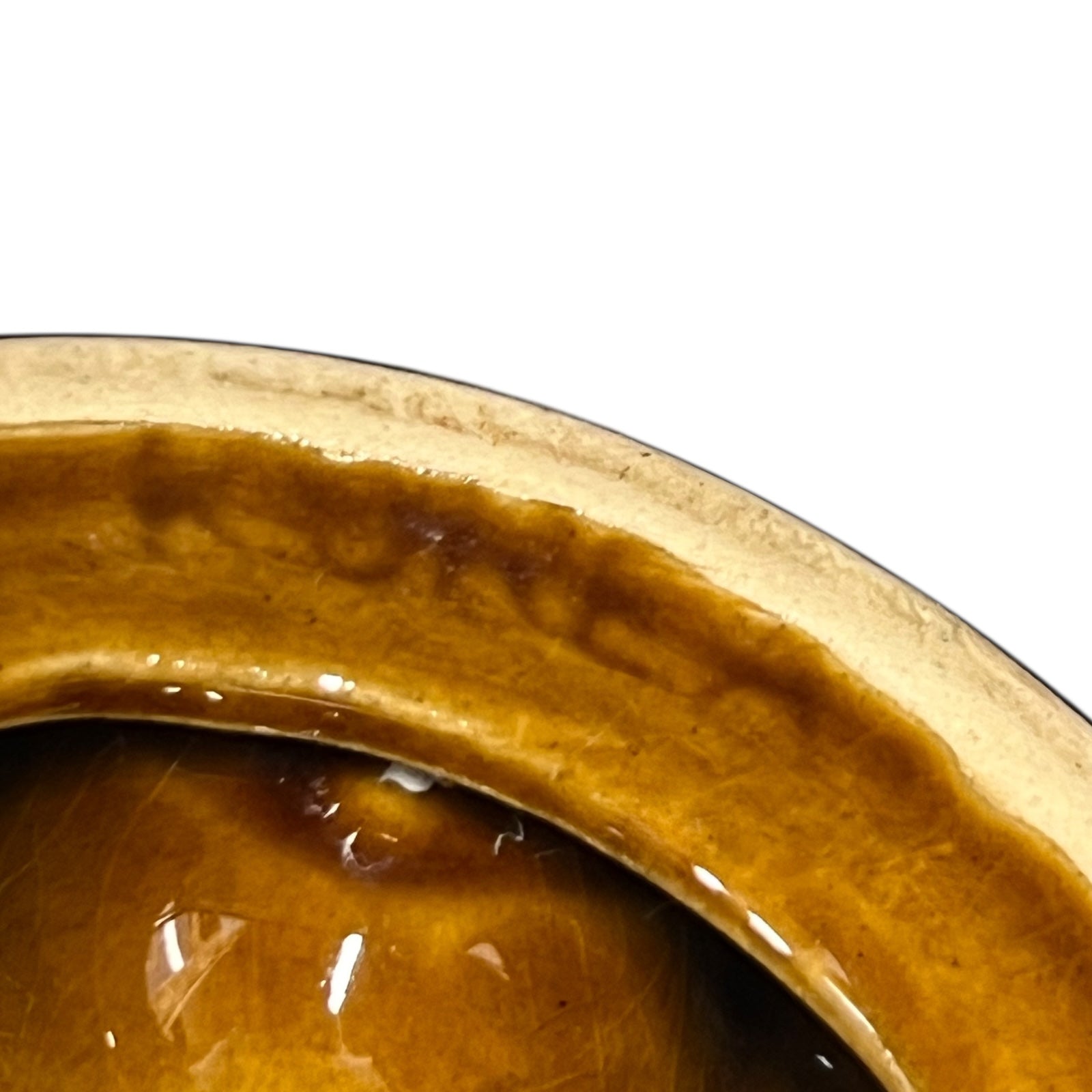 close up of a French brown ceramic escargots pot underside with multiple compartments on a white background