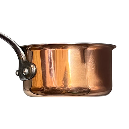 side view of copper saucepan on a white background