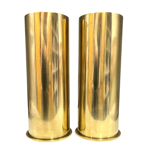Two brass WW1 shell cases on a white background