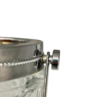 Close-up of a crystal ice bucket with silver lid and handle on a white background