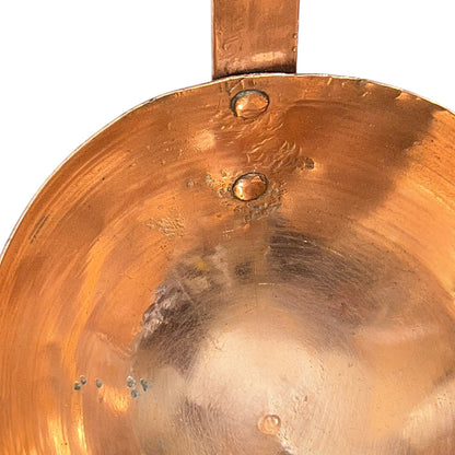 Close up of a French copper handmade ladle on a white background