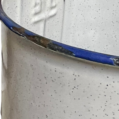 Close-up of a enamel planter with speckled pattern on a white background
