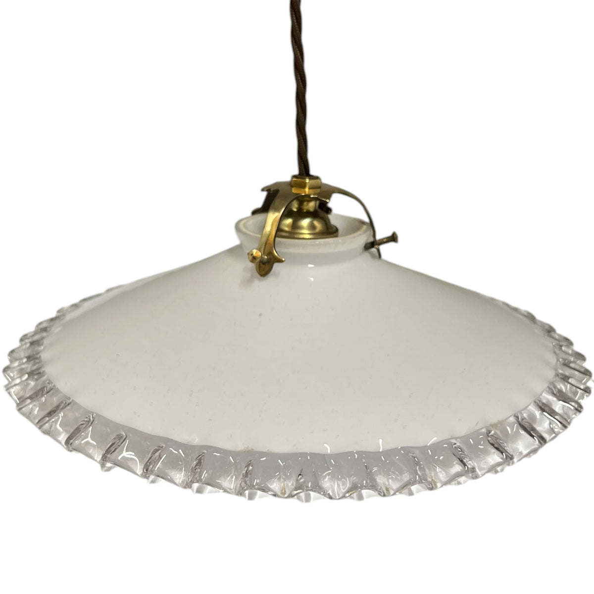 A vintage-style pendant light with a white glass shade featuring a scalloped, fluted edge and a brass metal fixture, suspended by a dark cord against a white background.