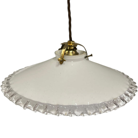 A vintage-style pendant light with a white glass shade featuring a scalloped, fluted edge and a brass metal fixture, suspended by a dark cord against a white background.