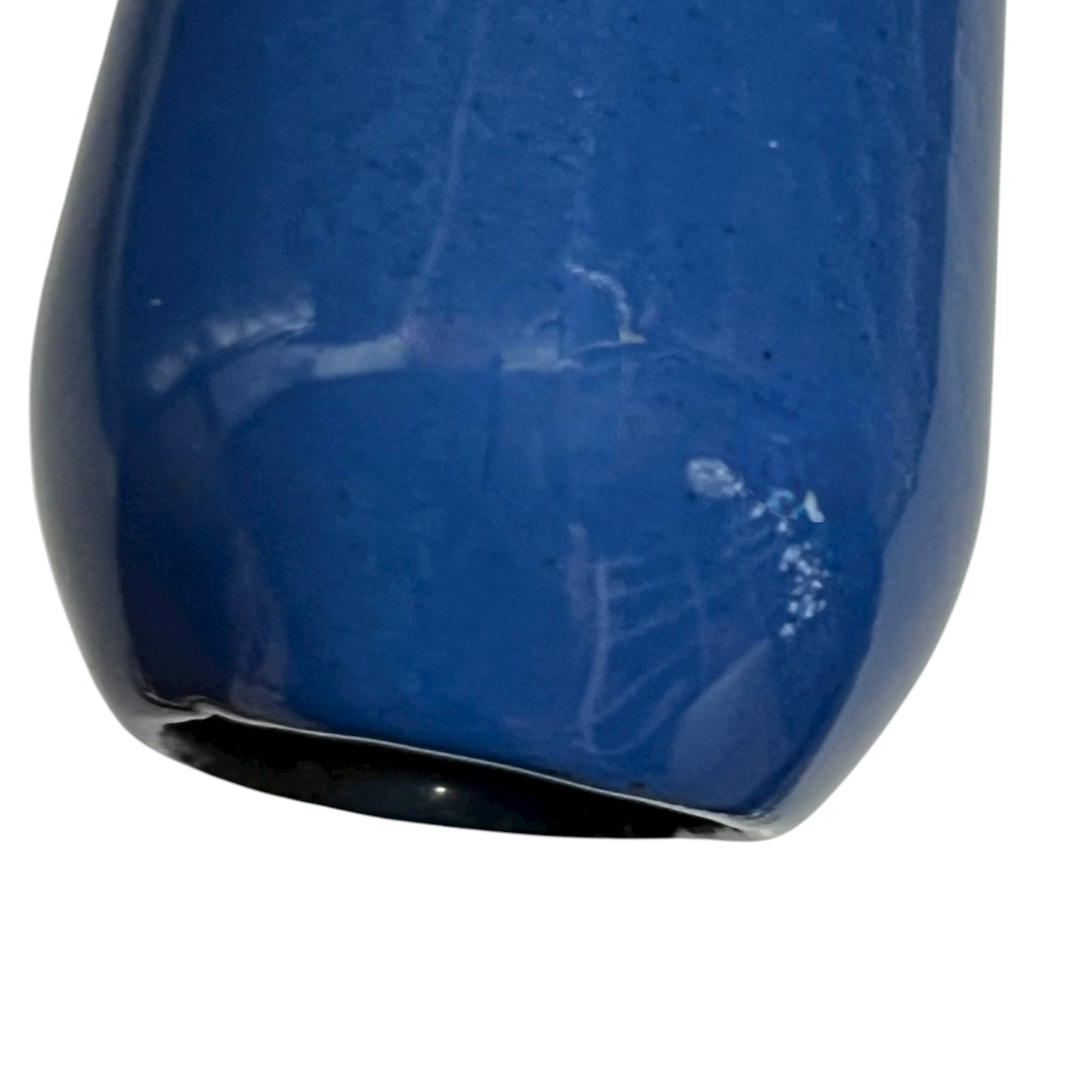 close up of blue cast iron pan with beige interior on a white background