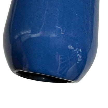 close up of blue cast iron pan with beige interior on a white background
