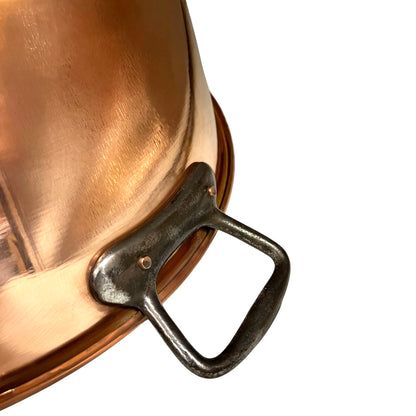 Close-up of a copper pot with a black handle on a white background