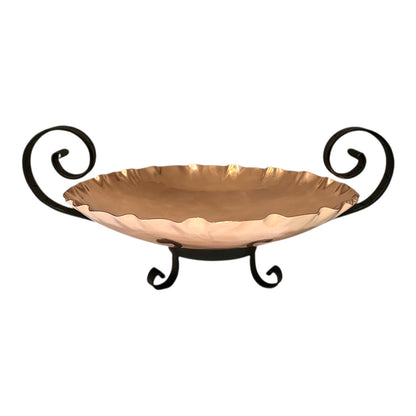 Decorative copper bowl with scrolled handles on a white background