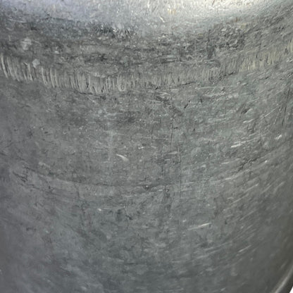 close up of metal milk churn on a white background
