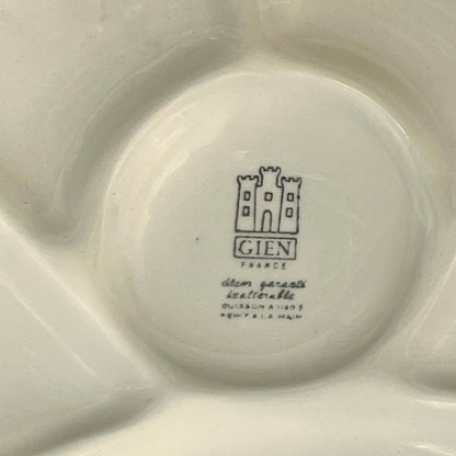 Close-up of a vintage fondue plate with detailed design on a white background