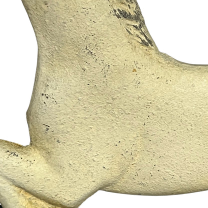A close-up of a cast iron horse shaped toilet roll holder, showing the rough, porous surface of an animal leg bone on a plain white background.