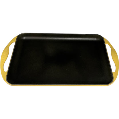 Le Creuset griddle with yellow handles on a white background