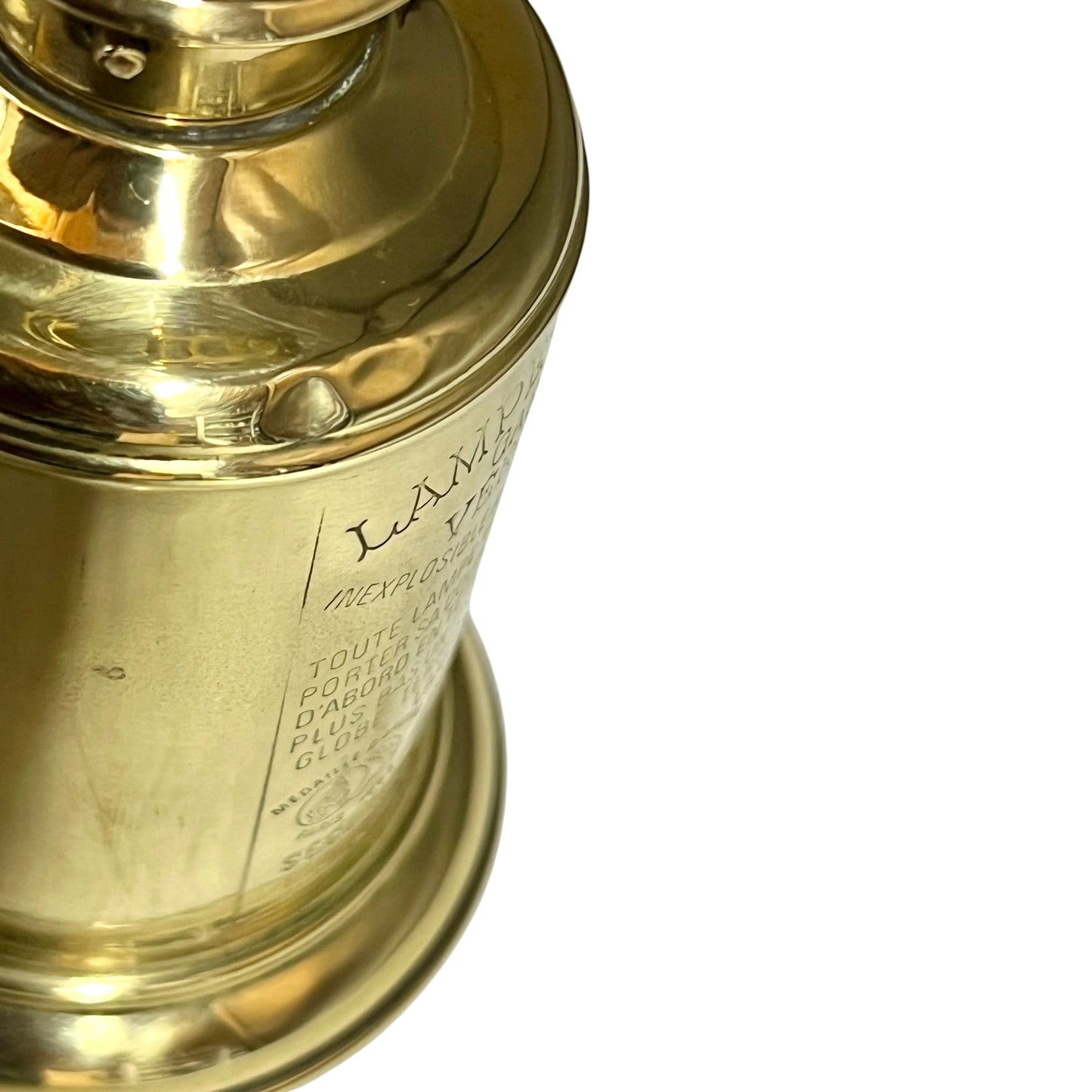Close-up of a brass lantern with engraved text on a white background