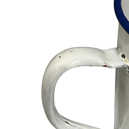 Close-up of a white enamel handle with a blue rim, showing some wear and scuffs on a white background.