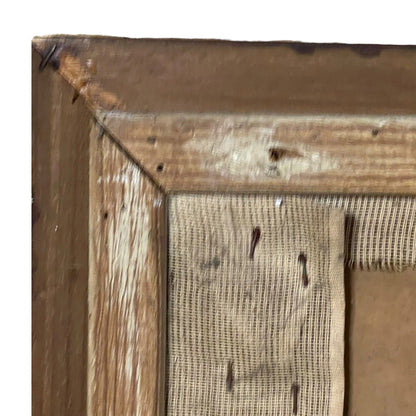 Close-up detail of a rustic wooden picture frame corner with a woven burlap mat and visible backing board.
