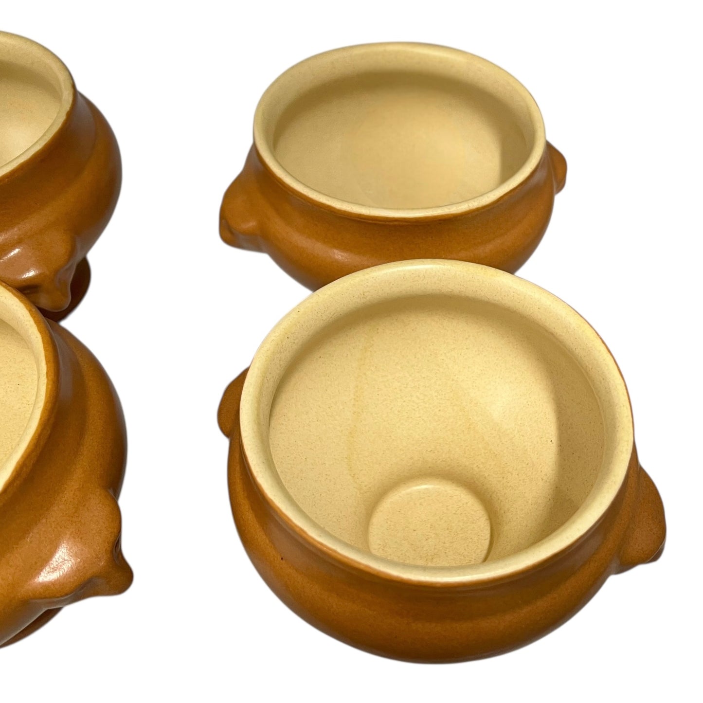 light brown ceramic French soup bowls with lions head handles on a white background 