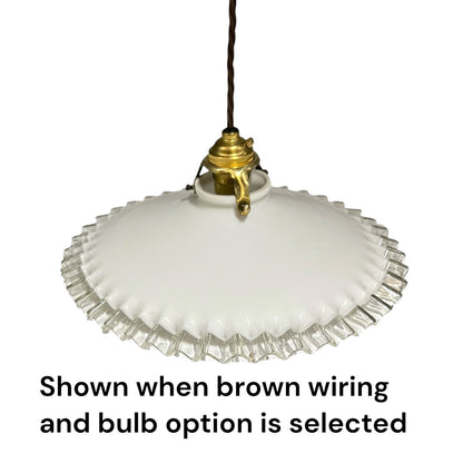 A vintage-style pendant light with a white ribbed glass shade and a brass fixture, suspended by a brown cord against a white background, with text below reading 'Shown when brown wiring and bulb option is selected'.