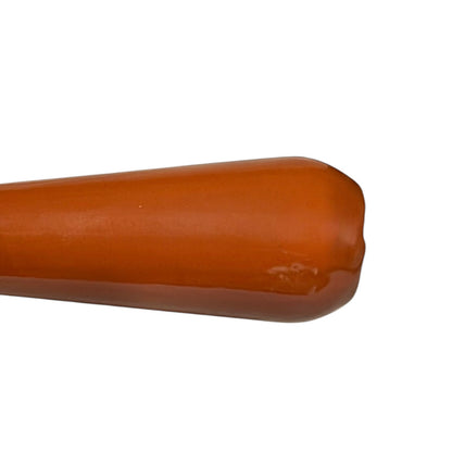 Close up of a rust coloured cast iron saucepan with lid on a white background