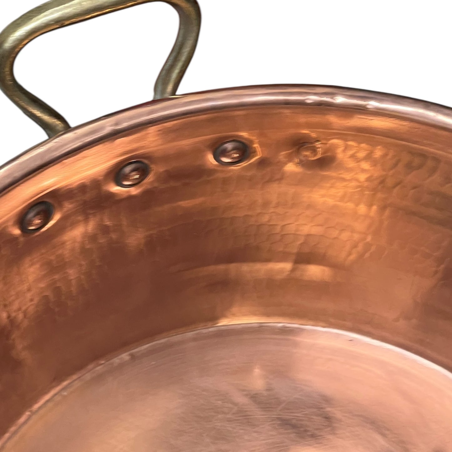 Close-up of copper sink with brass pop up waste on a white background