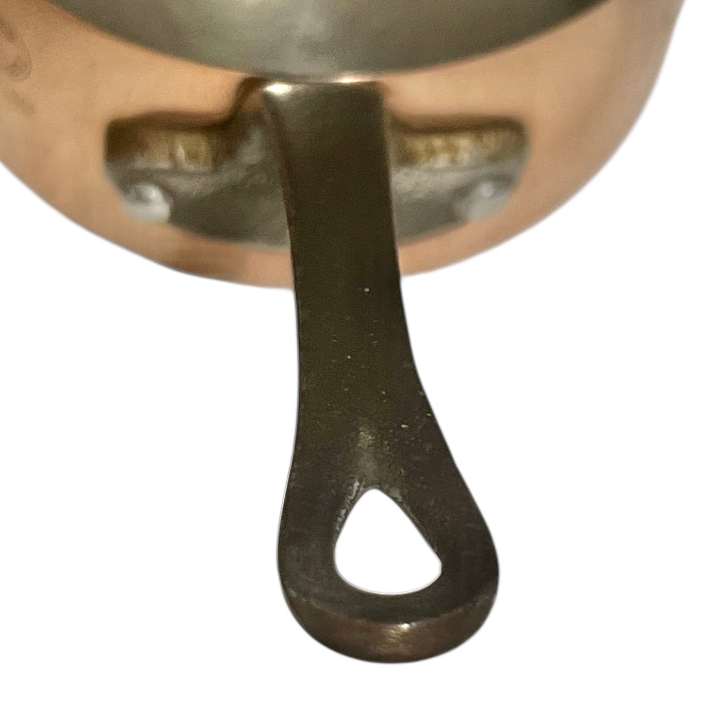 Close-up of copper cookware with iron handles on a white background