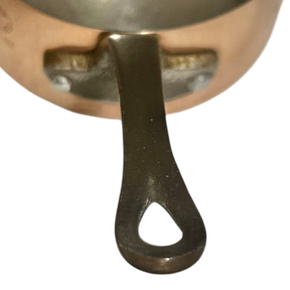 Close-up of copper cookware with iron handles on a white background