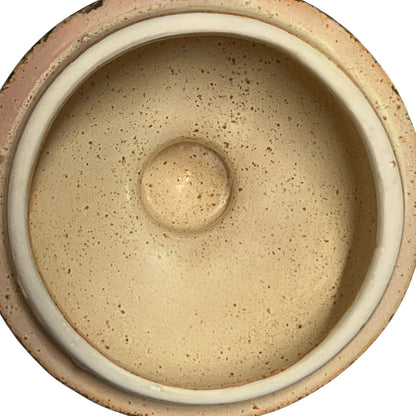 Close-up of a ceramic jar with embossed design on a white background