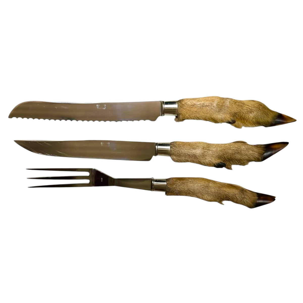 A three-piece hunting or game cutlery set featuring a serrated knife, a standard knife, and a carving fork, all with natural brown animal hide handles on a plain white background.