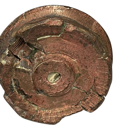 WW1 British brass fuse now repurposed as a paperweight on a white background