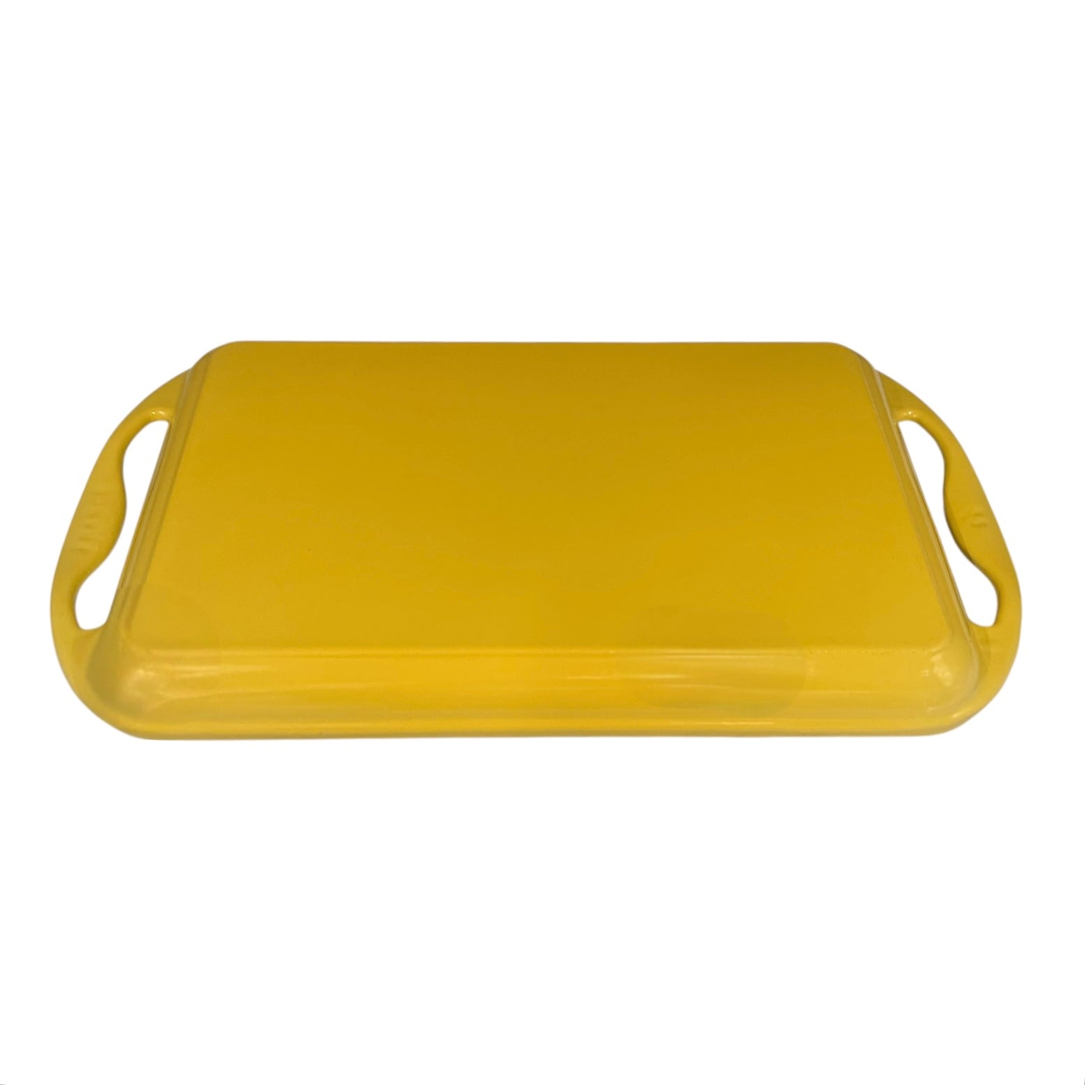 Yellow Le Creuset griddle pan with handles on a white background