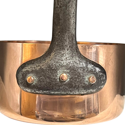Close-up of a copper pot with a metal handle on a white background