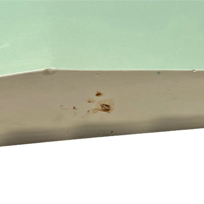 back view of pale green ceramic shelf on a white background