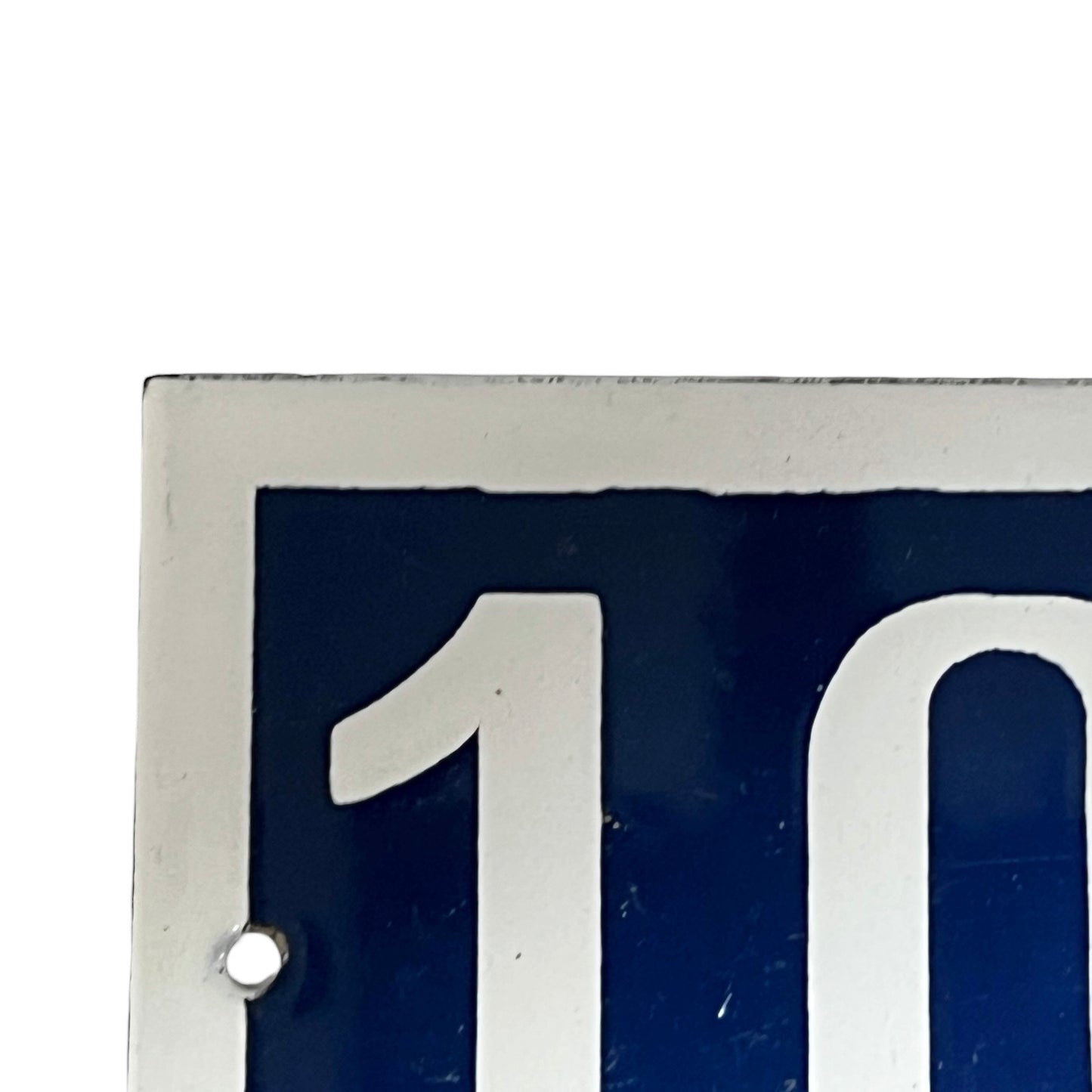 Close-up of a blue sign with white number on a white background 