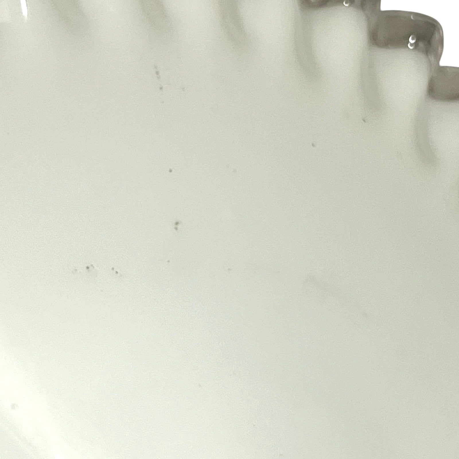 close up of white glass lampshade with a scalloped edge