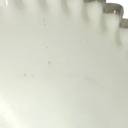 close up of white glass lampshade with a scalloped edge