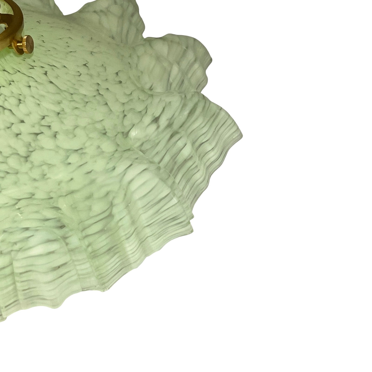 A close-up of a textured, ruffled light fixture shade in a pale sage green color, showing a brass-colored metal mounting ring in the top-left corner against a solid white background.
