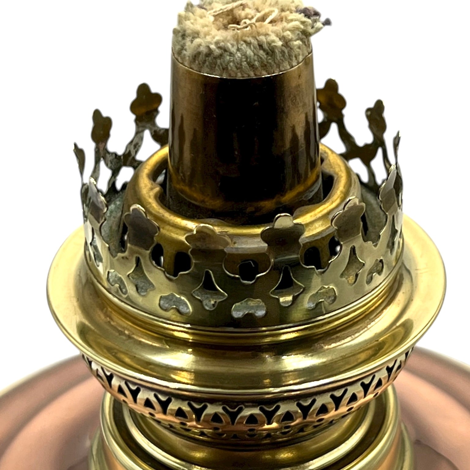 Brass oil lamp with intricate design on a white background