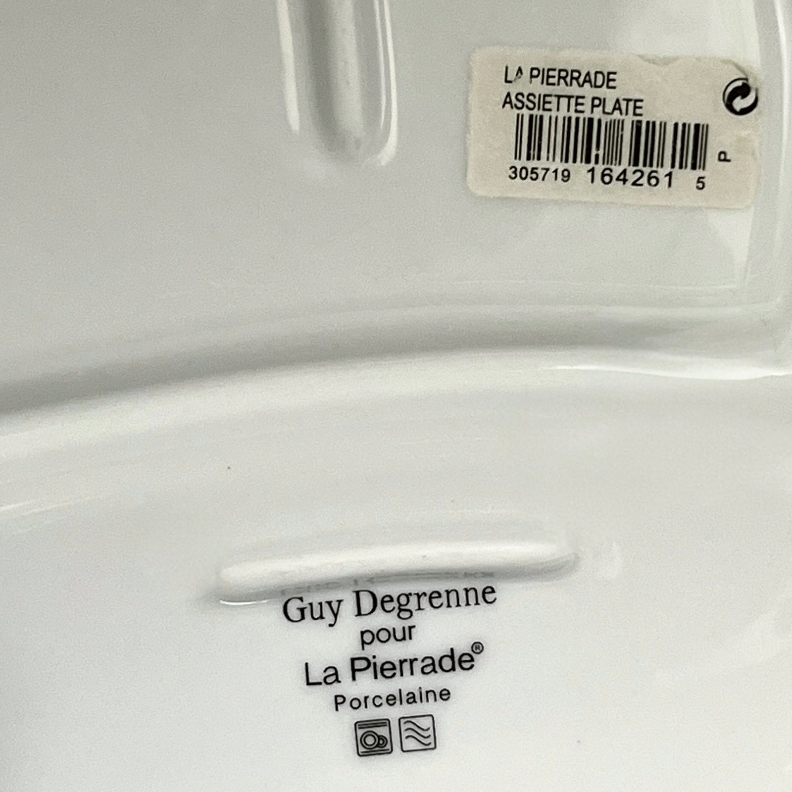 White plate with 'Guy Degrenne pour La Pierrade' branding and a barcode label.