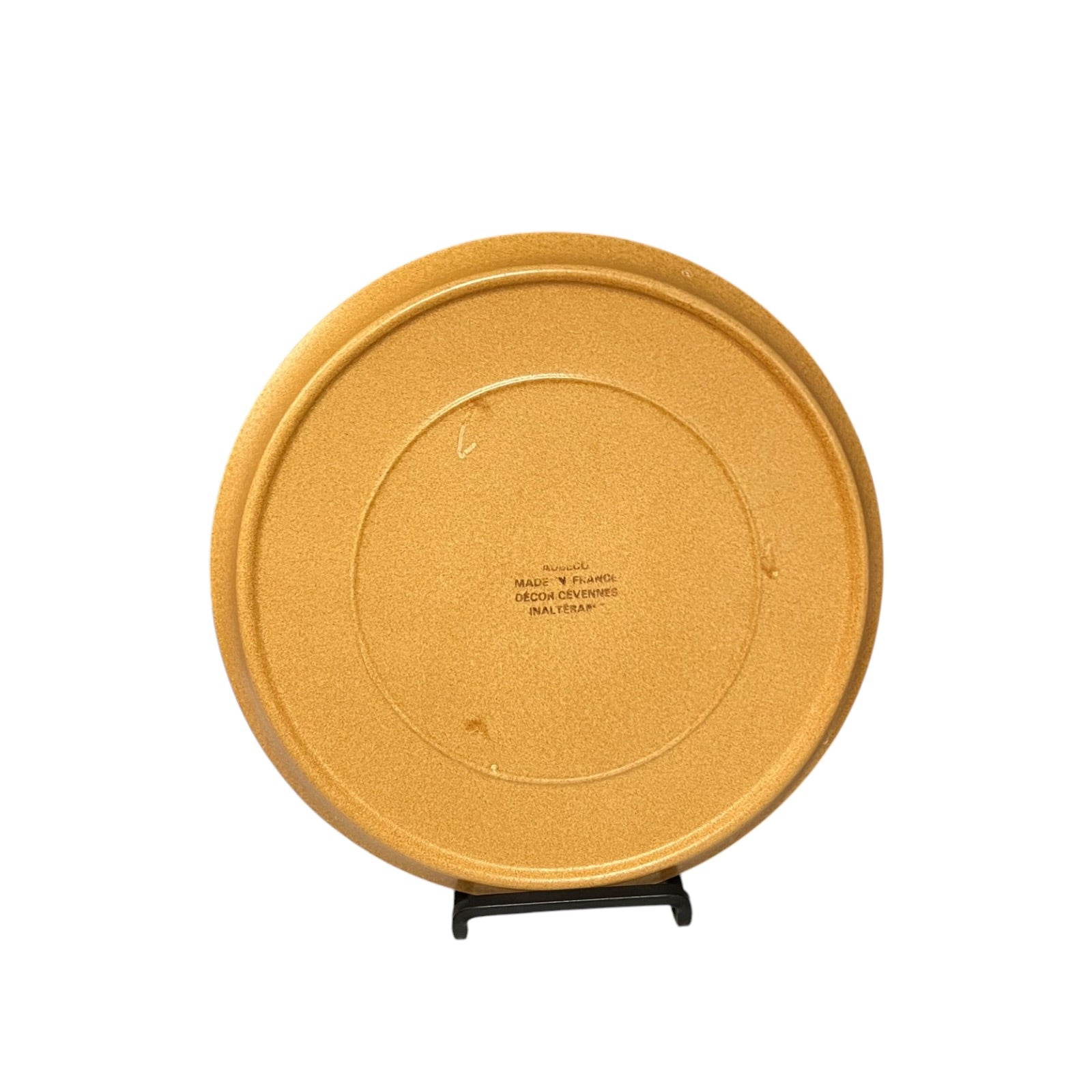 brown-coloured plates with a makers stamp on a metal stand and on a white background