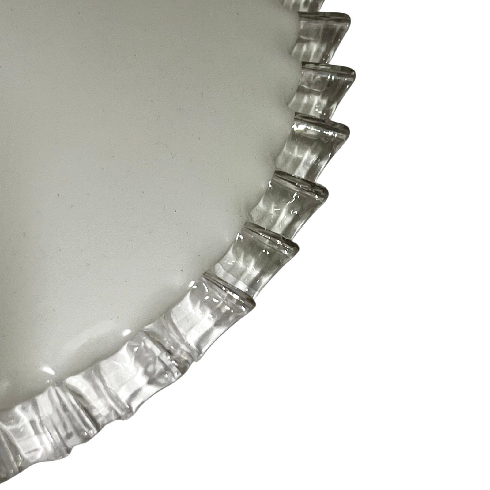 Close-up of a pendant light with white glass shade and brass fitting on a white background