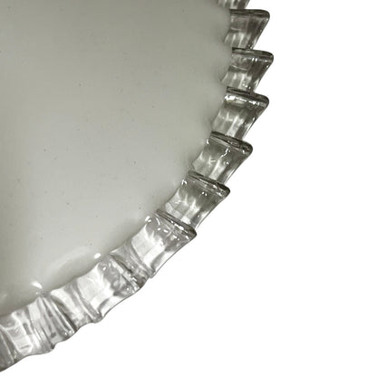 Close-up of a pendant light with white glass shade and brass fitting on a white background