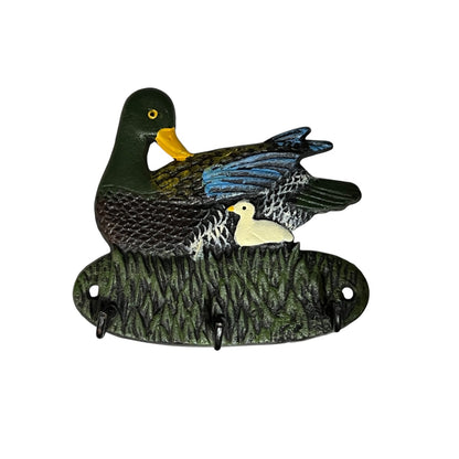 A decorative duck-shaped wall hook holder featuring a dark green adult duck, a small white duckling, and textured reeds, with three hanging hooks at the base, shown on a plain white background.