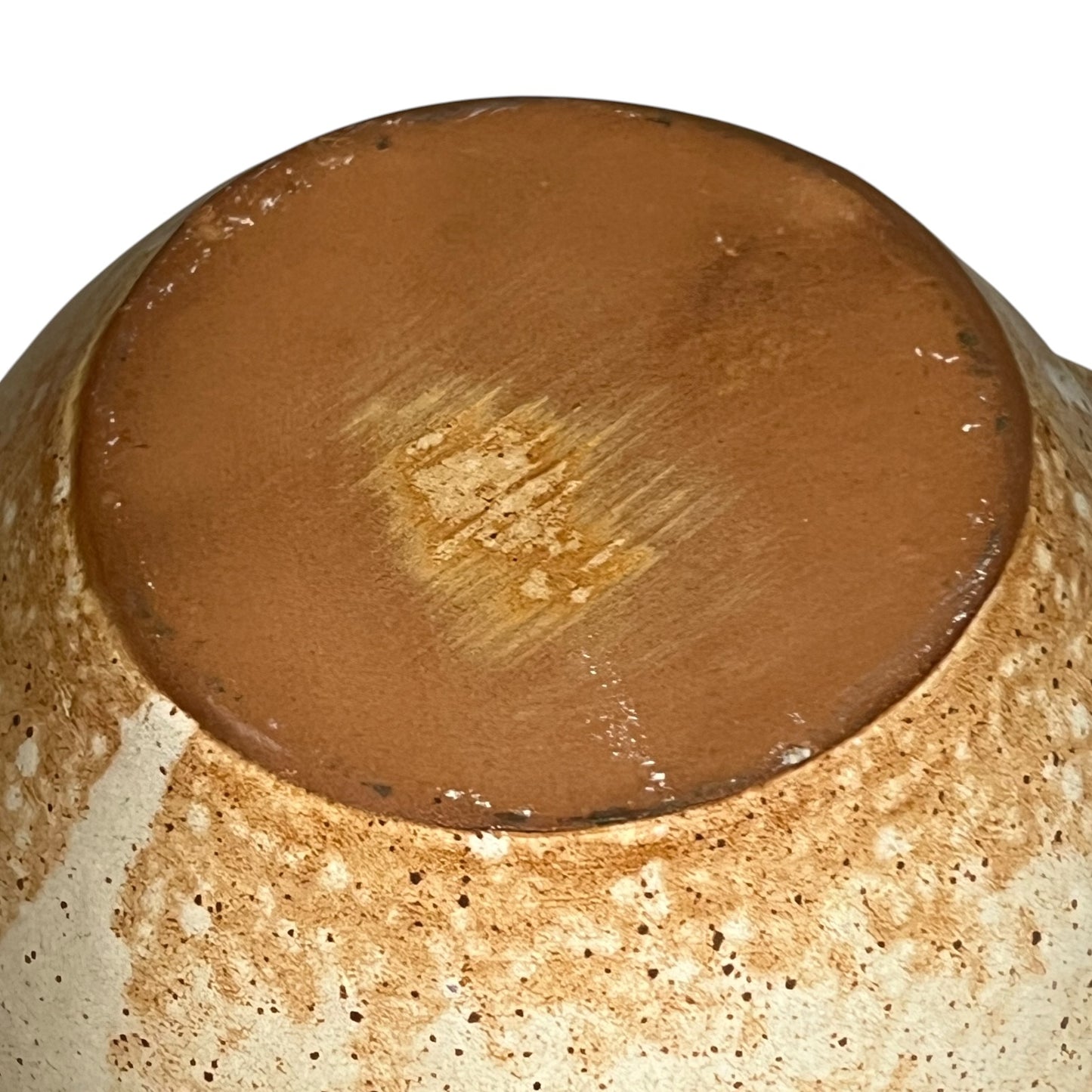 Close-up of a ceramic jug base with a brown glaze on a white background