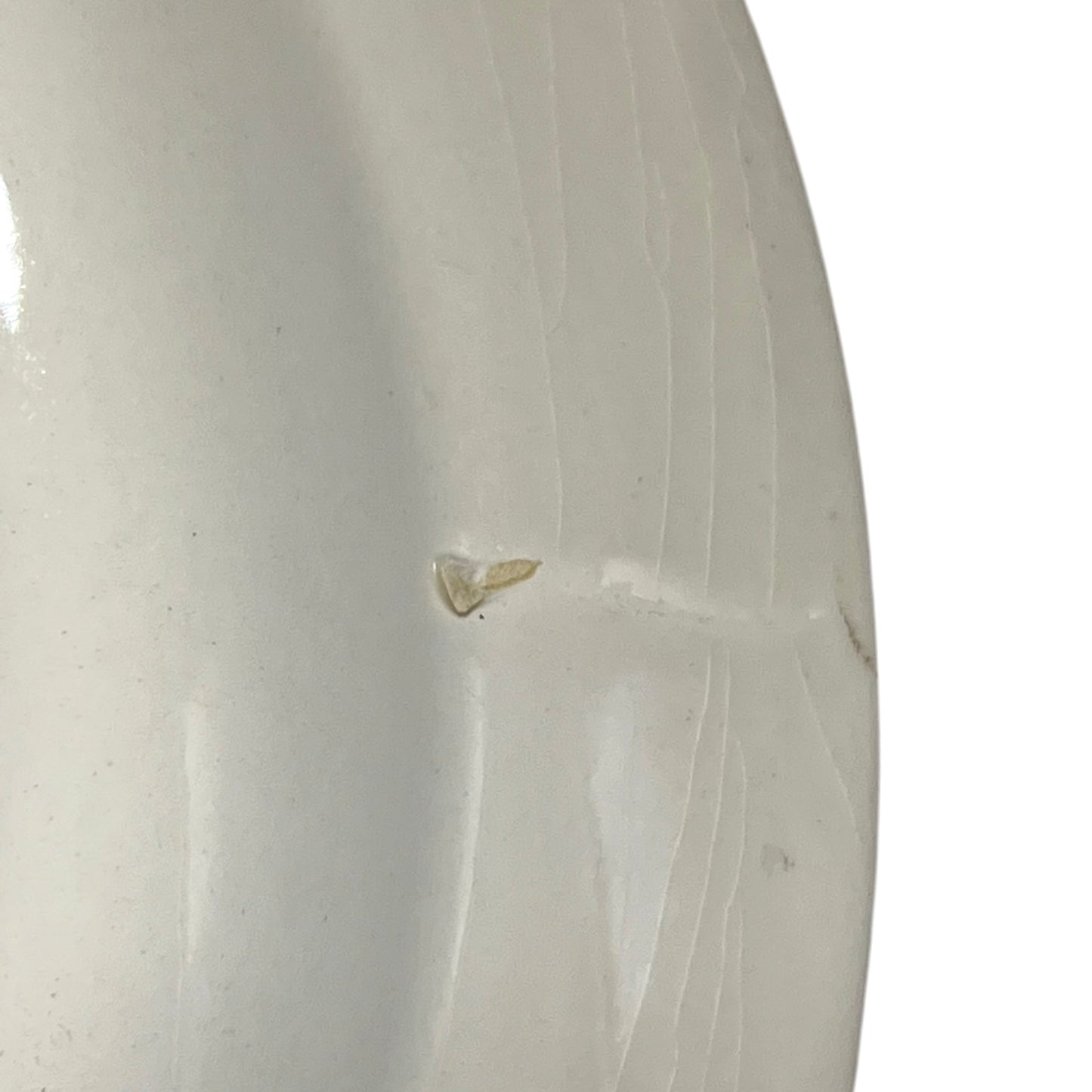 Close-up of a white ceramic vase with visible texture and slight imperfections.