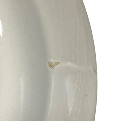 Close-up of a white ceramic vase with visible texture and slight imperfections.