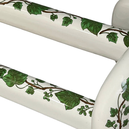 White and green leaf patterned towel rails on a white background