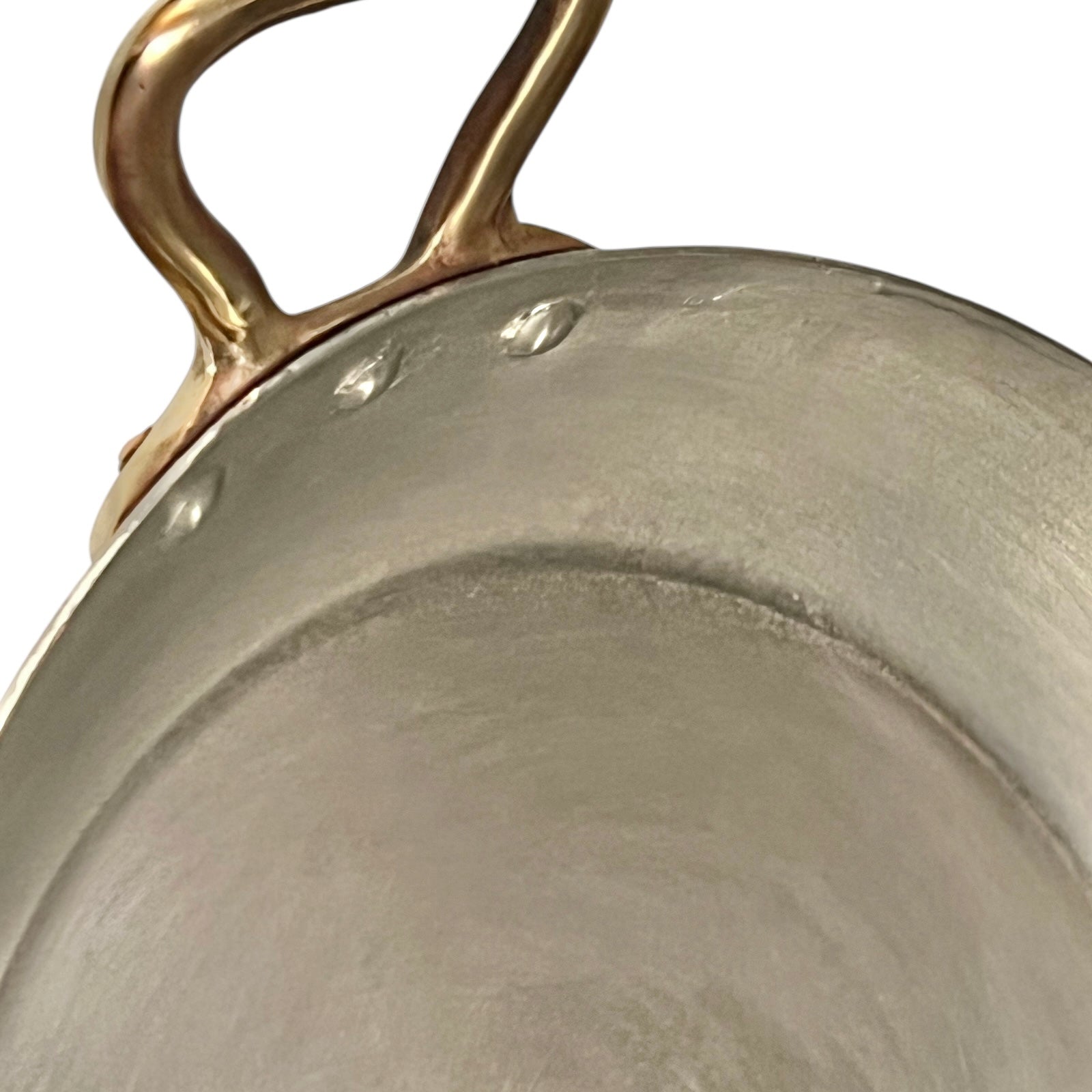 close up of French copper round gratin pan with brass handles and tin lining on a white background